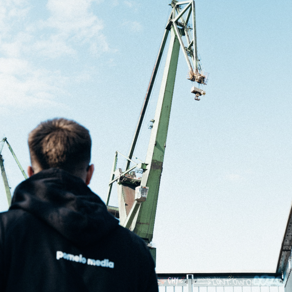 Osoba patrząca się na dźwig stoczniowy